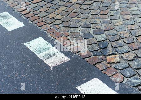 Paving stones pathway and asphalt with markings texture. Cobblestone and asphalt background Stock Photo