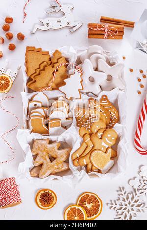 Top view of unpacked christmas present with sweets on a white textured surface, close-up. Christmas celebration concept Stock Photo