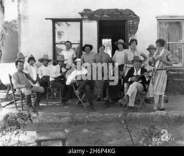 WARNER BAXTER BESSIE LOVE and RAYMOND HATTON on set location candid with Crew Members playing music together during location filming in Southern Arizona of A SON OF HIS FATHER 1925 director VICTOR FLEMING novel Harold Bell Wright Paramount Pictures Stock Photo