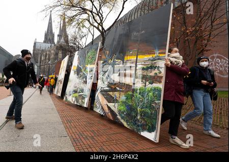 Cologne, Germany. 17th Nov, 2021. Climate activists carry the painting 'Das Gro?e Gelingen' from 2021 by the artist couple Helge & Saxana through Cologne towards Art Cologne. The action is intended to demonstrate against the demolition of the village of Lützerath, which is threatened by the Garzweiler open-cast lignite mine. Credit: Federico Gambarini/dpa/Alamy Live News Stock Photo