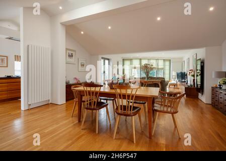 Clare, England - March 9 2020: Domestic furnished residential open plan dining and living room space with kitchen area in the background Stock Photo