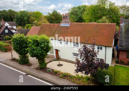 Stoke by Clare, England - October 17 2019: Detached British Cottage taken from a public place on the roadside with tiled roof, large chimney, multi pa Stock Photo