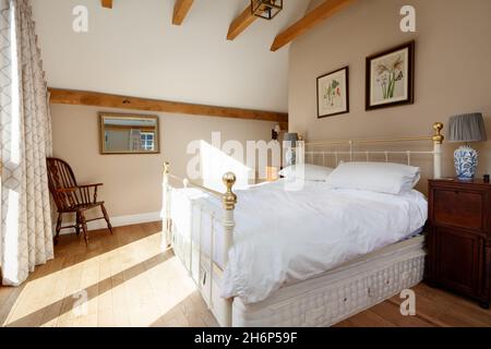 Stoke By Clare, England October 17 2019: Bedroom interior inside traditional english cottage with exposed beams, bed and sloping ceiling Stock Photo