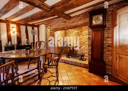 Stoke By Clare, England October 17 2019: Dining room interior inside traditional english cottage with exposed brickwork and beams, inglenook fireplace Stock Photo