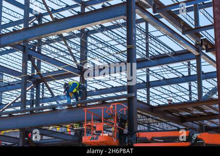 NEW ORLEANS, LA, USA - NOVEMBER 16, 2021: Worker welding steel beams of building and generating sparks and smoke Stock Photo