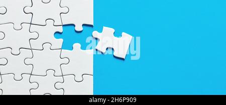 One missing puzzle piece with blue background with copy space. Stock Photo