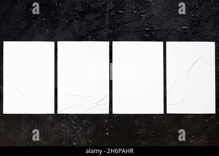 black urban wall texture with four wrinkled glued poster templates Stock Photo