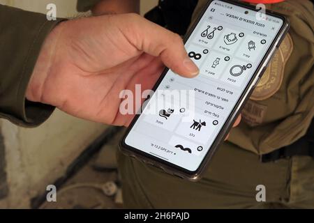 An Israeli Soldier from the rescue unit of the Home Front Command shows a military search and rescue application which enables to identify victims in collapsed buildings during a search and rescue drill in a large demolition site on November 16, 2021 in Tel Aviv, Israel. The Home Front drill simulated search and rescue operation preparing for scenarios that could destroy buildings and trap citizens as a result of a major earthquake or massive barrages of rockets. Stock Photo