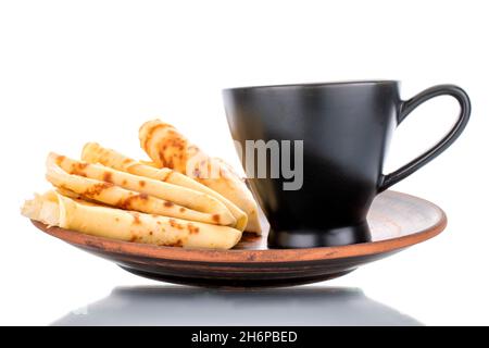 Three sweet homemade pancakes on a ceramic saucer with a black cup, close-up, isolated on white. Stock Photo