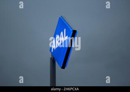 Beleuchtetes ARAL Logo in den Farben blau und weiß bei Nacht, vor einer ARAL Tankstelle in Düsseldorf, Deutschland.