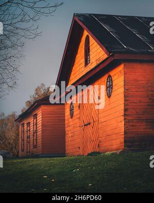 Old small wooden houses painted in orange. Scandinavian style. Traditional Finnish architecture. Colorful building facades in village in Finland Stock Photo