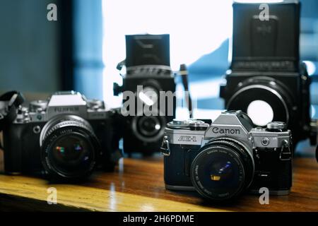 Izmir, Turkey - July 9, 2021: Illustrative editorial Close up shot of Canon AE1 analog film camera and other cameras defocused on the background. Stock Photo