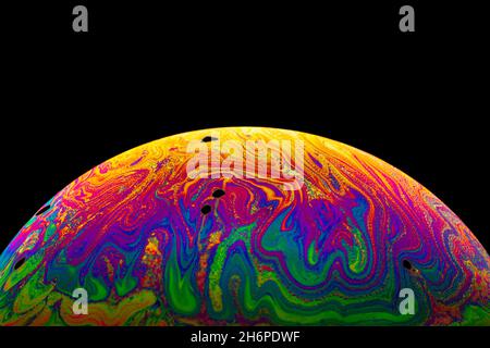 Virtual reality space with abstract multicolor psychedelic planet. Closeup Soap bubble like an alien planet on black background. Stock Photo