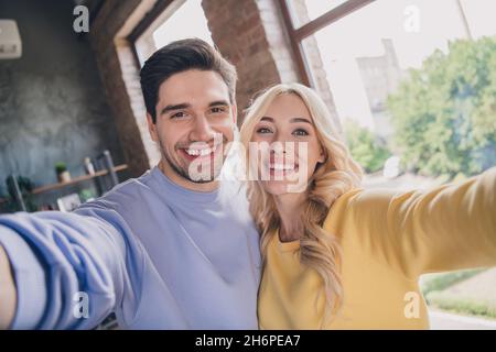 Self-portrait of attractive trendy cheerful couple staying spending free time at home loft industrial interior indoors Stock Photo