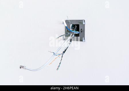 Home. New electrical wiring installation, plastic socket box and electrical wires for outlet sockets on plastered wall Stock Photo
