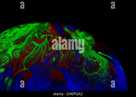 Virtual reality space with abstract multicolor psychedelic planet. Closeup Soap bubble like an alien planet on black background. Stock Photo