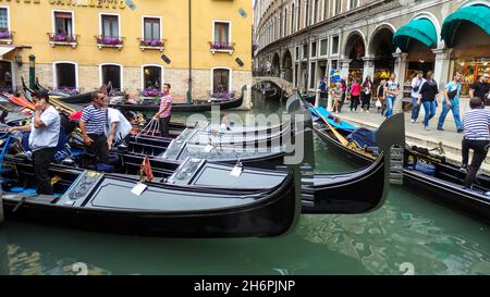 VENICE, ITALY - MAY 31, 2016: Gondoliers and gondolas on the canal waiting for a tourist.Gondolas is a traditional Venetian rowing boat, well suited t Stock Photo