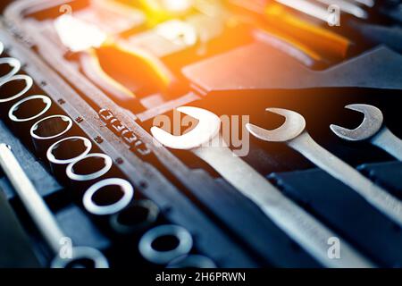 It's close-up car repair tool box. Set of new chrome wrenches and bits. Background with sunlight. Advertising photo. Stock Photo