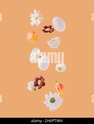 White daisies, tulips, roses, Easter eggs and various flowers floating on orange background. Minimal and creative spring concept. Stock Photo