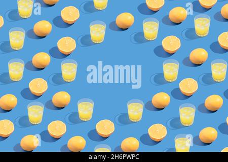 Trendy bright summer pattern made of lemon slaces and cocktail glasses on blue background. Stock Photo