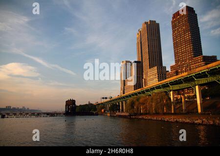 A summer sunset on the highway and skyscrapers over Riverside Park on Hudson River Stock Photo