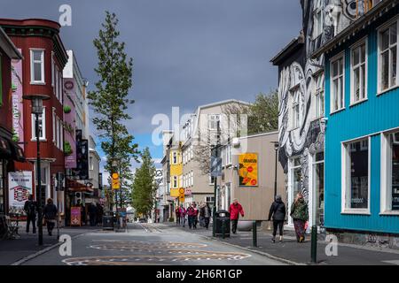 Reykjavik, Iceland - June 12 2021: Colorful houses at Laugavegur street in Reykjavik downtown. People walking down the street. Stock Photo