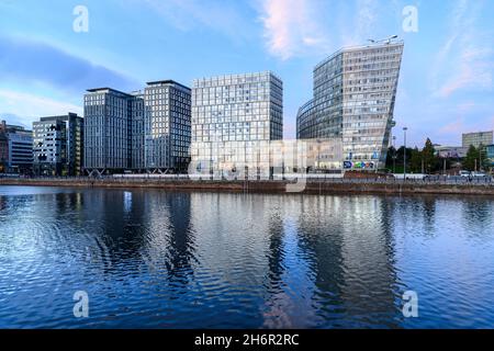 Early evening with the dramatic, funky, new, buildings at Liverpool One reflected in Canning Dock at Liverpool's historic Albert Dock. Stock Photo
