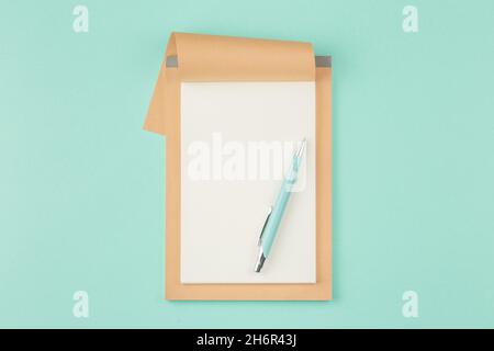 Open craft notepad on cyan background Stock Photo