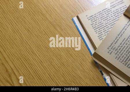 Flat lay of a wooden table on which there are some open books on one side, image with copy space Stock Photo