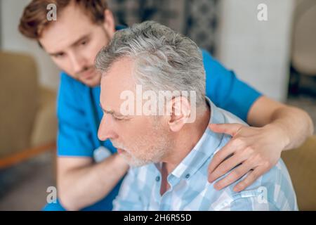Attentive healthcare professional taking care of his patient Stock Photo