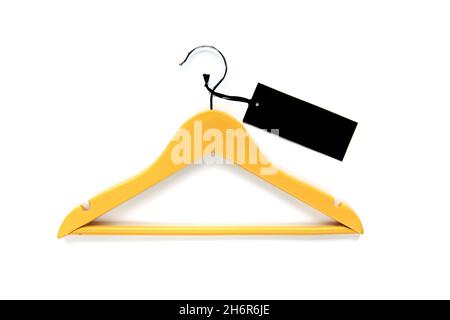Wooden yellow coat hanger with black paper label isolated on white background. Clothing tag, label blank mockup template, to place your design. Black Stock Photo