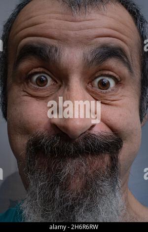Middle aged Caucasian male with goatee making funny faces at camera Stock Photo