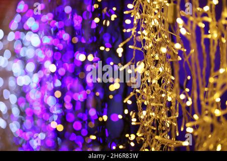 Festive lights on electric garlands. Colorful Christmas decorations, New Year illumination in night city Stock Photo
