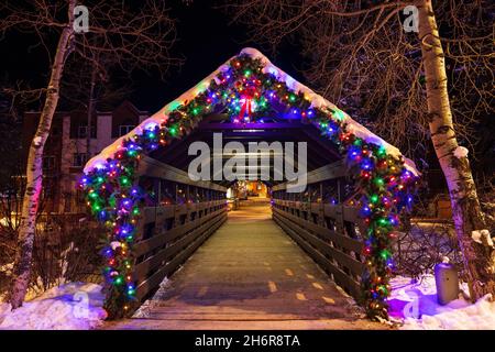 Winter scene with Christmas lights on the Gore Creek covered bridge in Vail Village, Colorado, USA Stock Photo