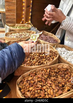 Closeup female hand giving money for dried fruits and nuts at market in Ukraine Stock Photo