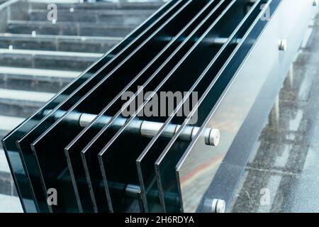 Forced glass handrail in parallel lines in office building Stock Photo