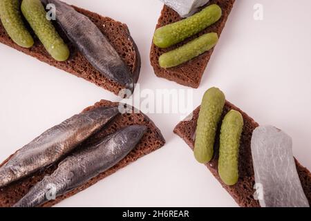 Sandwich with fish and lightly salted cucumbers on black bread.  Stock Photo