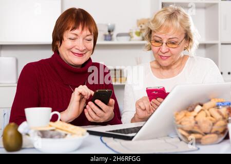 Couple of mature females with telephone Stock Photo