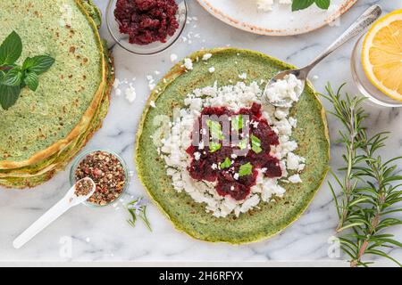 Close-up of pink pancakes with beetroot and feta, and green pancakes with spinach Stock Photo