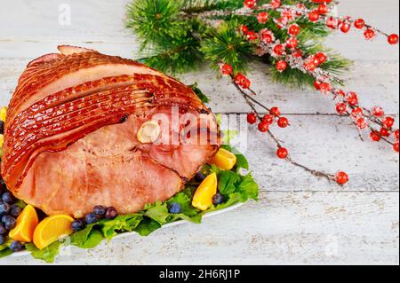 Whole pork ham with fresh fruits. Holiday Christmas meal. Stock Photo
