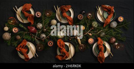 Flat-lay of Christmas table setting on dark table Stock Photo