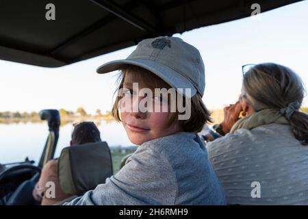 Boy in a safari jeep in a baseball cap looking at the camera Stock Photo