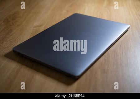 electronic devices on wooden table, close up. Laptop closed. Technology device. Stock Photo