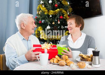 Aged couple exchanging gifts Stock Photo