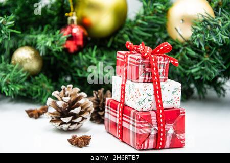 Three gift boxes with ribbon bows and Christmas tree branch Stock Photo