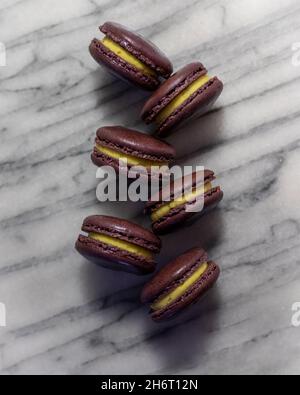 Passionfruit Macarons on White Marble Stock Photo