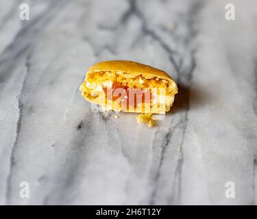 Mango Macaron Cross Section on White Marble Stock Photo