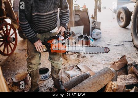 Close-up of a man holding a chainsaw. Stock Photo
