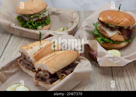 Tempting feast of food on the dinner table with the tri tip sandwich as the featured item. Stock Photo