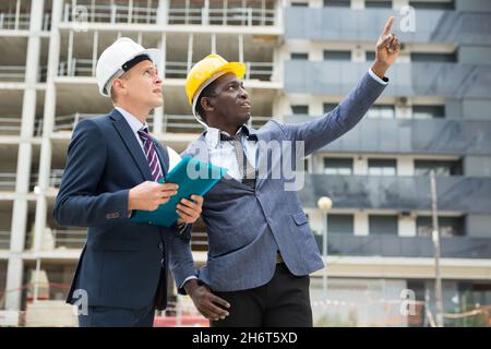Architects talking about project documentation on construction plant Stock Photo